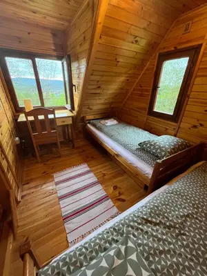 a bedroom with a bed and a desk in a cabin at Izdebka na Podchybiu in Izdebnik