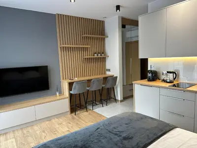 a kitchen with a television and a counter with stools at Apartamenty WIERCHY in Klikuszowa