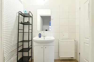 a white bathroom with a sink and a mirror at Urban Nest Apartments Party Szewska21 in Kraków