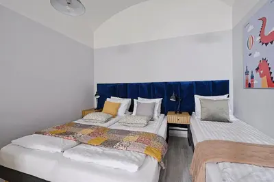 two beds in a room with blue curtains at Urban Nest Apartments Party Szewska21 in Kraków