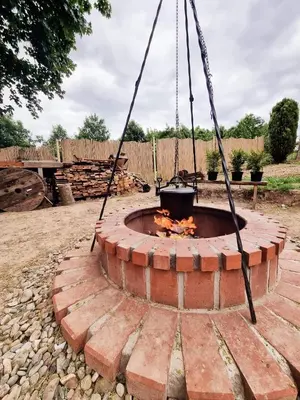 a fire pit in a yard with a swing at Zaczarowana Furmanka in Antolka
