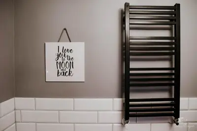 a bathroom with a black and white sign on the wall at Zaczarowana Furmanka in Antolka