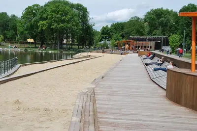 a boardwalk in a park with people sitting on benches at THE SOUL of Nowa Huta - free garage in Kraków