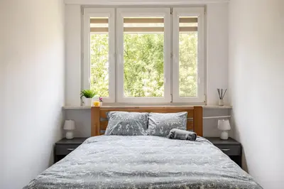 a bedroom with a large bed with two windows at The Best Location in Cracow for City Break in Kraków