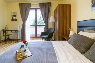 a bedroom with a bed with a tray with flowers on it at Przytulny apartament z parkingiem blisko Tauron Areny in Kraków