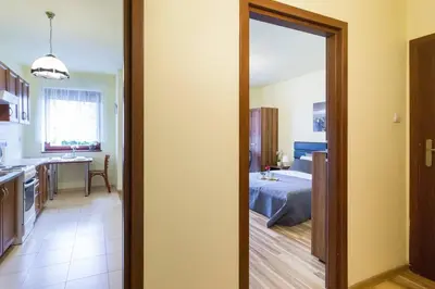a room with a kitchen and a bed in a room at Przytulny apartament z parkingiem blisko Tauron Areny in Kraków