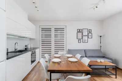 a kitchen and dining room with a table and a couch at Zabłocie Apartment Best Location to Explore Krakow in Kraków