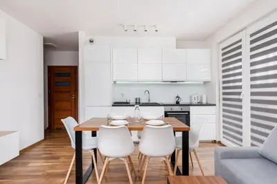 a kitchen and dining room with a wooden table and chairs at Zabłocie Apartment Best Location to Explore Krakow in Kraków