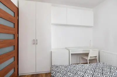 a white bedroom with a bed and a desk at Zabłocie Apartment Best Location to Explore Krakow in Kraków