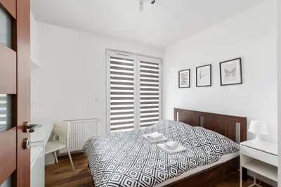 a white bedroom with a bed and a window at Zabłocie Apartment Best Location to Explore Krakow in Kraków