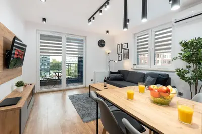 a living room with a table and a couch at Romanowicza Prestige Place in Kraków