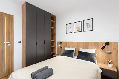 a bedroom with a large bed with a black cabinet at Romanowicza Prestige Place in Kraków