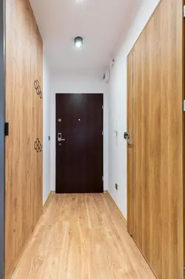 an empty room with two doors and a wooden floor at Romanowicza Prestige Place in Kraków