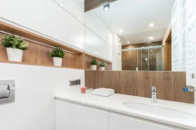 a bathroom with a sink and a mirror at Romanowicza Prestige Place in Kraków