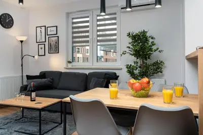 a living room with a table and a couch at Romanowicza Prestige Place in Kraków