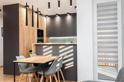 a kitchen with a wooden table and chairs at Romanowicza Elegant Place in Kraków