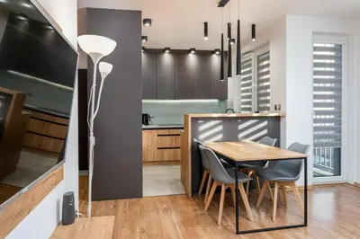 a kitchen and dining room with a table and chairs at Romanowicza Elegant Place in Kraków