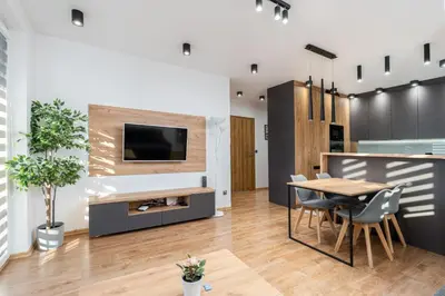 a living room with a table and a tv on a wall at Romanowicza Elegant Place in Kraków