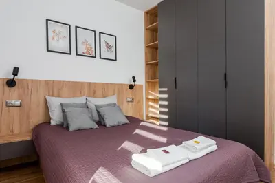 a bedroom with a purple bed with two towels on it at Romanowicza Elegant Place in Kraków