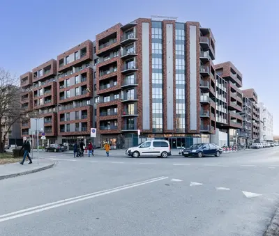 a street with cars parked in front of a building at Romanowicza Elegant Place in Kraków