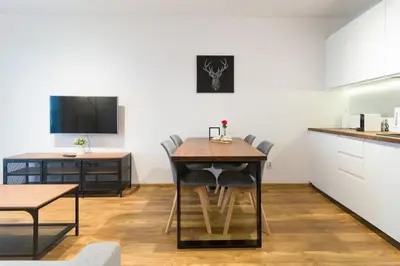 a kitchen and dining room with a table and chairs at Zabłocie Cozy Escape in Kraków