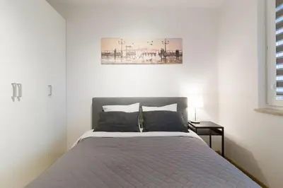 a bedroom with a bed with a picture on the wall at Zabłocie Cozy Escape in Kraków