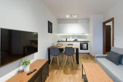 a living room with a couch and a table with chairs at Zabłocie Cozy Escape in Kraków