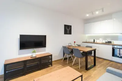 a living room with a dining table and a kitchen at Zabłocie Cozy Escape in Kraków
