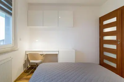 a bedroom with a bed and a desk and a chair at Zabłocie Cozy Escape in Kraków