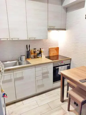 a kitchen with white cabinets and a sink and a table at TOM ROOM - Cracow City Centre in Kraków