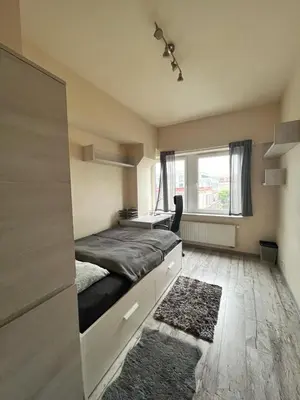 a bedroom with a bed with a desk and a window at TOM ROOM - Cracow City Centre in Kraków