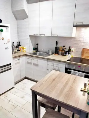 a kitchen with white cabinets and a wooden table at TOM ROOM - Cracow City Centre in Kraków