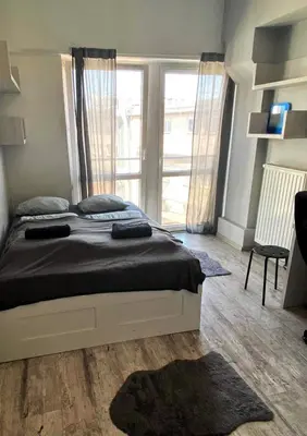a bedroom with a bed and a large window at TOM ROOM - Cracow City Centre in Kraków