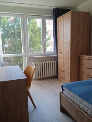 a bedroom with a bed and a desk and windows at U Cioci in Kraków