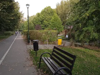 a park bench sitting on the side of a sidewalk at U Cioci in Kraków