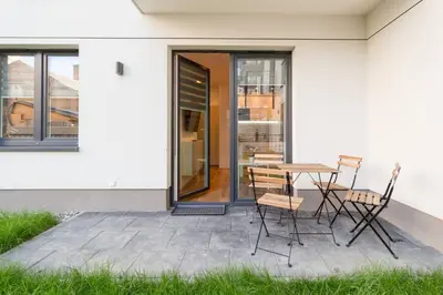 a patio with a table and chairs next to a building at Cozy apartment with garden prestigious location in Kraków