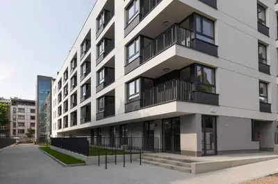 a white building with balconies on the side of it at Cozy apartment with garden prestigious location in Kraków
