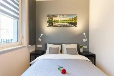 a bedroom with a white bed with two night stands at Cozy apartment with garden prestigious location in Kraków