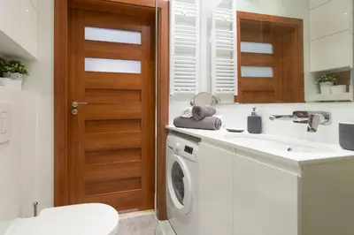 a bathroom with a washing machine and a sink at Cozy apartment with garden prestigious location in Kraków