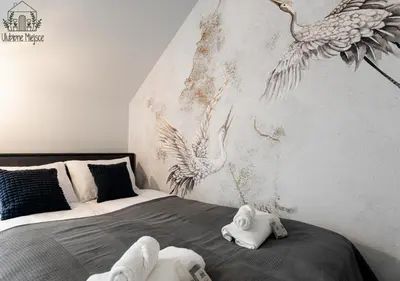 a bedroom with a bed with birds on the wall at ULUBIONE MIEJSCE ZATOR in Zator
