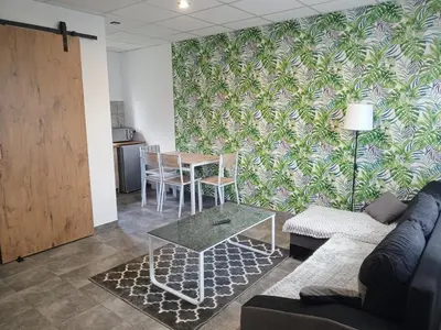 a living room with a couch and a table at Domki - Apartamenty Complex in Zator