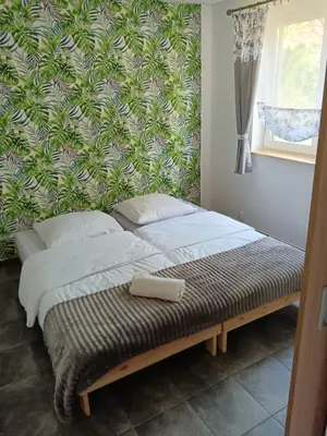a bed in a bedroom with a green wall at Domki - Apartamenty Complex in Zator
