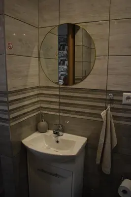 a bathroom with a sink and a mirror at Domki - Apartamenty Complex in Zator