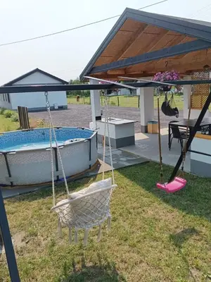 a swing in a yard next to a house at Domki - Apartamenty Complex in Zator