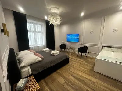 a bedroom with a large bed and a chandelier at Apartament z Jacuzzi Kraków SHINE Starowiślna in Kraków