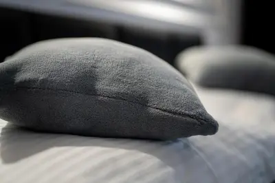 a black pillow sitting on top of a bed at Apartament z Jacuzzi Kraków SHINE Starowiślna in Kraków