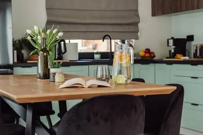 a kitchen table with a book and a vase of flowers at ObidovaGorce in Obidowa
