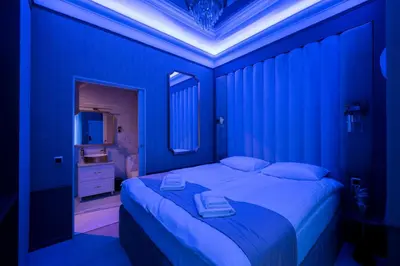 a blue bedroom with a large bed with a blue light at Salomea krakow apartments Bożego Ciała in Kraków