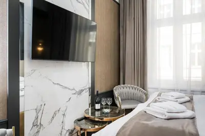 a hotel room with a bed and a flat screen tv at Salomea krakow apartments Bożego Ciała in Kraków
