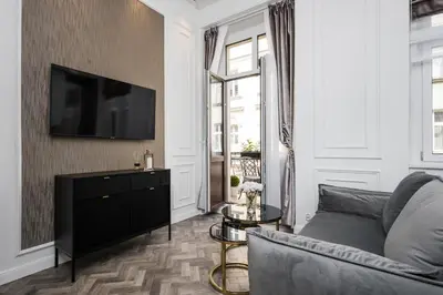 a living room with a couch and a tv on a wall at Salomea krakow apartments Bożego Ciała in Kraków